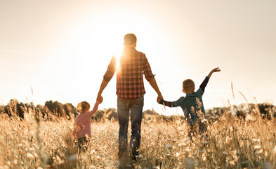 Father and his children walking in the field