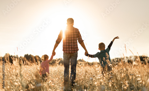 Father and his children walking in the field