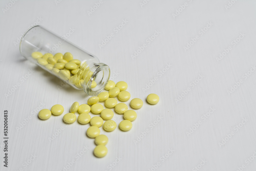 yellow tablets on a white table yellow tablets on a white table