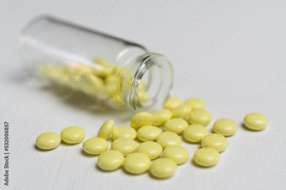 yellow tablets on a white table yellow tablets on a white table