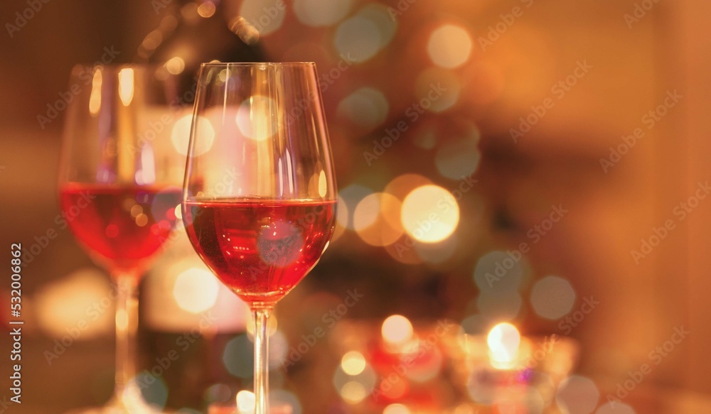Two glasses of red wine and Christmas lights background. Two glasses of red wine and Christmas lights background.