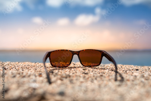 sunglasses on the beach and beautiful sunset 
