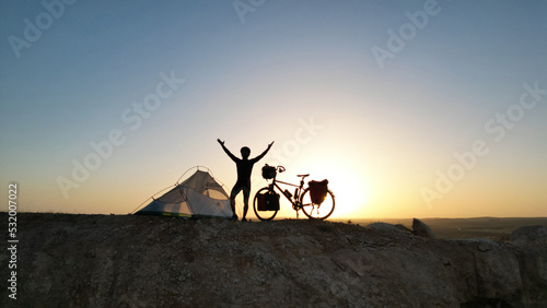 successful young man camping on the roads with his bike