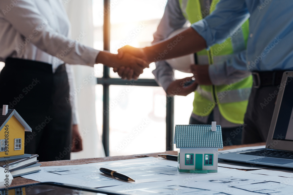 Architect and engineer work together and shaking hands to welcome home design projects to work in the same way and work together as a team.