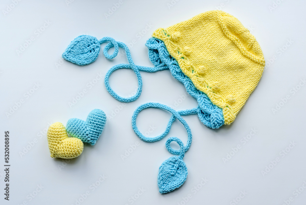 Fototapeta premium Beautiful baby knitted clothes and a toys for a newborn baby