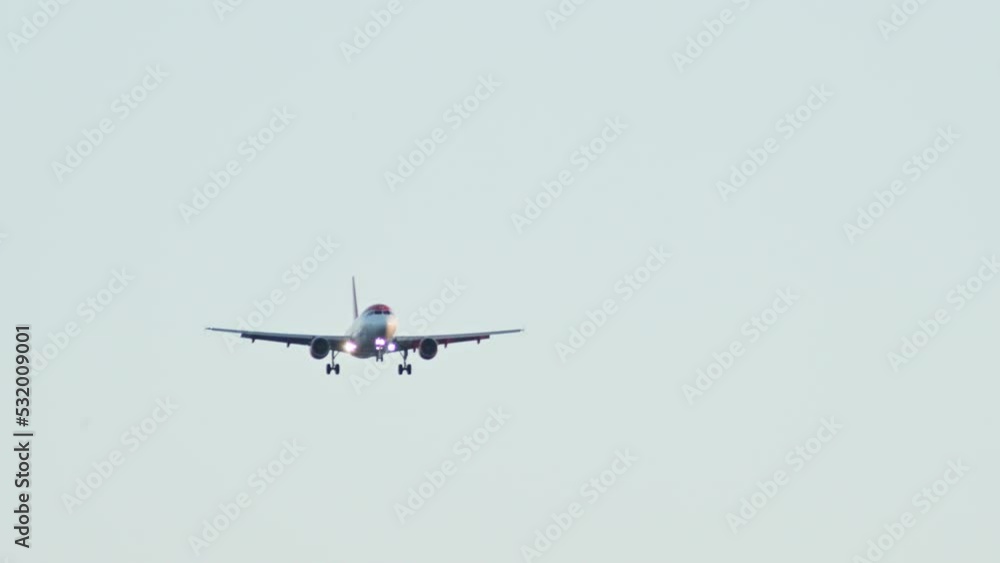 The plane is flying to land at the airport. Slow motion video of a passenger plane descending. High quality 4k footage The plane is flying to land at the airport. Slow motion video of a passenger plane descending. High quality 4k footage