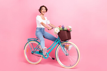 Full length photo of excited funky lady wear white crop top riding bike fast isolated pink color background