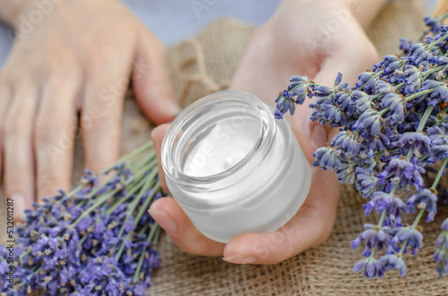 Moisturizing cream in female hands. Lavender Moisturizer