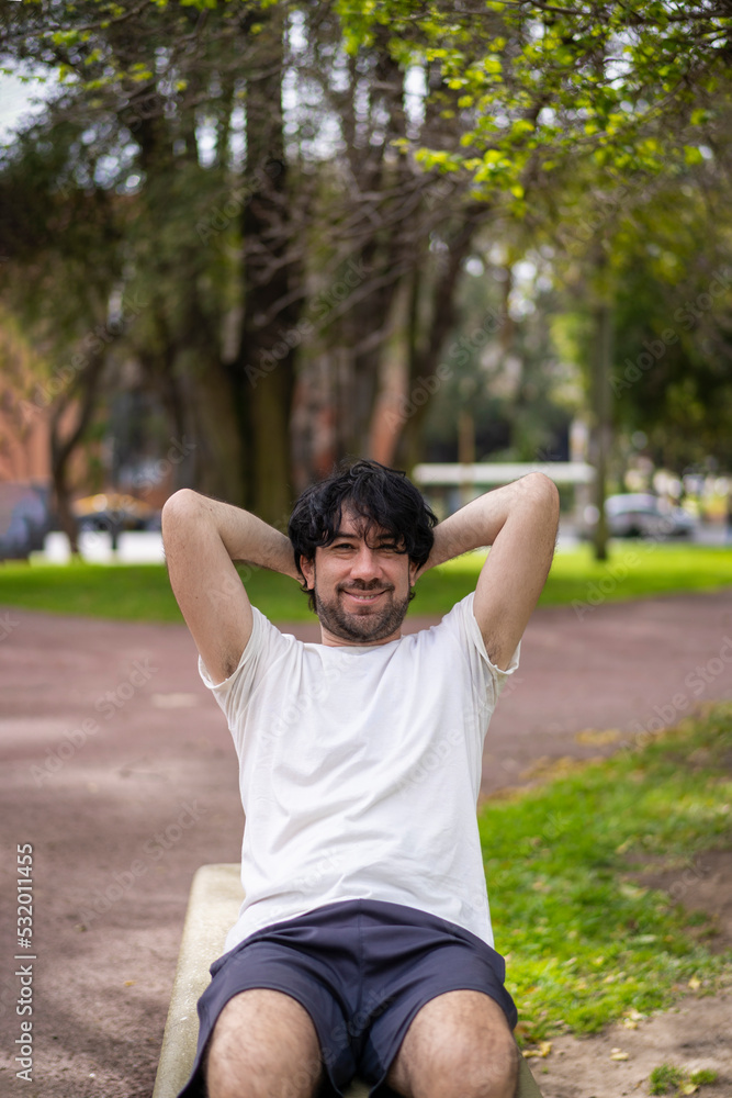 Portrait of handsome attractive mature bearded athletic latin man guy 40s doing sit-ups in the park. Portrait of handsome attractive mature bearded athletic latin man guy 40s doing sit-ups in the park.