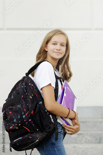  Back to school. Teenager, Junior High school Student smiling in a school yard,  smiling and holding books at a break at school.