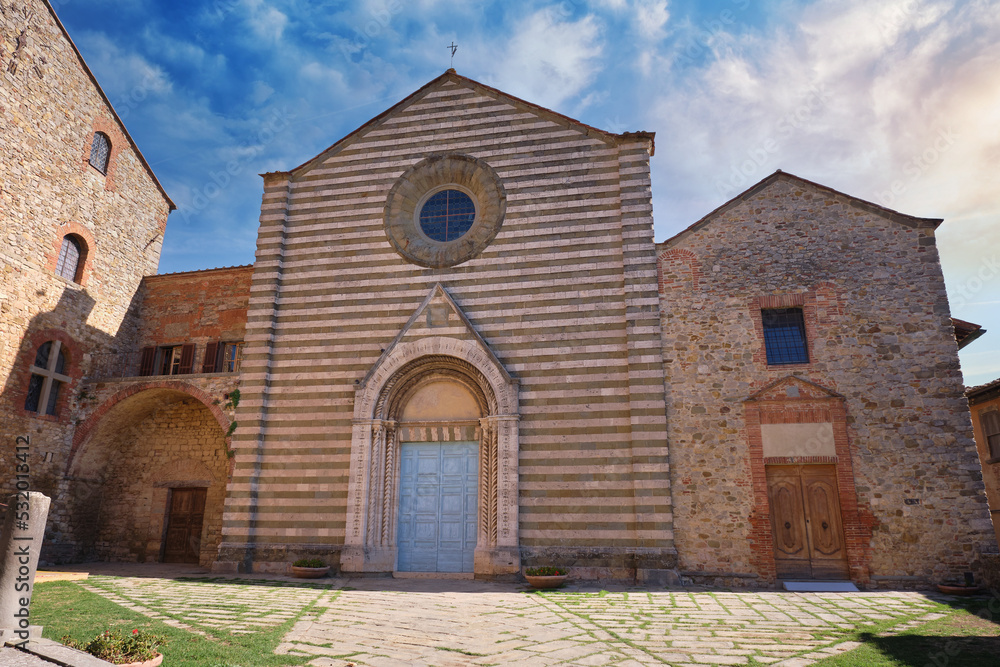 medieval church in the tuscan town of lucignano at sunset