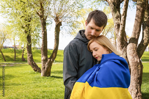 Young people together with the flag of Ukraine in the park on a sunny day. Free lifestyle concept