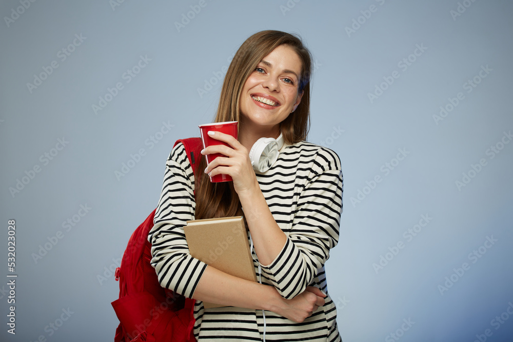 Young adult student millennial woman with book and red backpack holding red coffee cup. Isolated female portrait. Young adult student millennial woman with book and red backpack holding red coffee cup. Isolated female portrait.