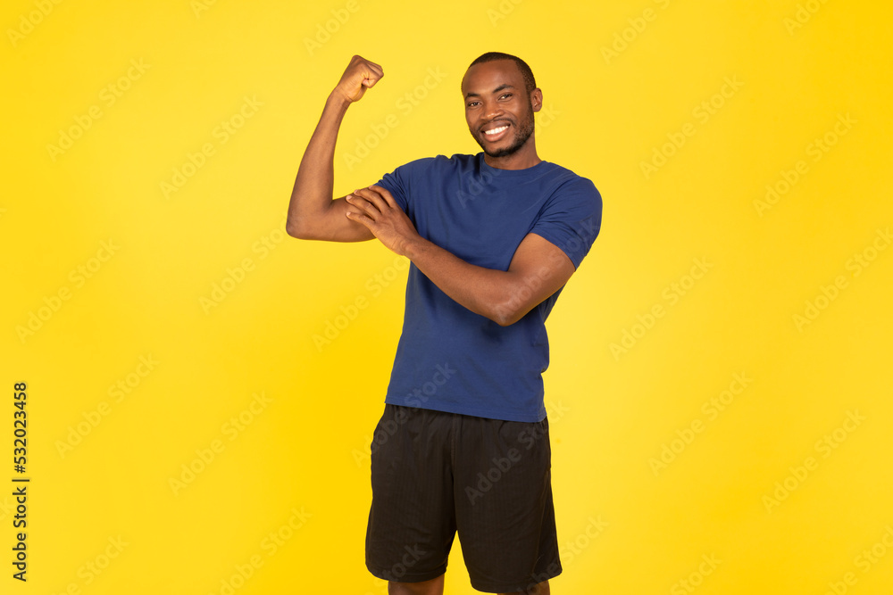 Black Male Athlete Showing Biceps Posing After Workout, Yellow Background Black Male Athlete Showing Biceps Posing After Workout, Yellow Background