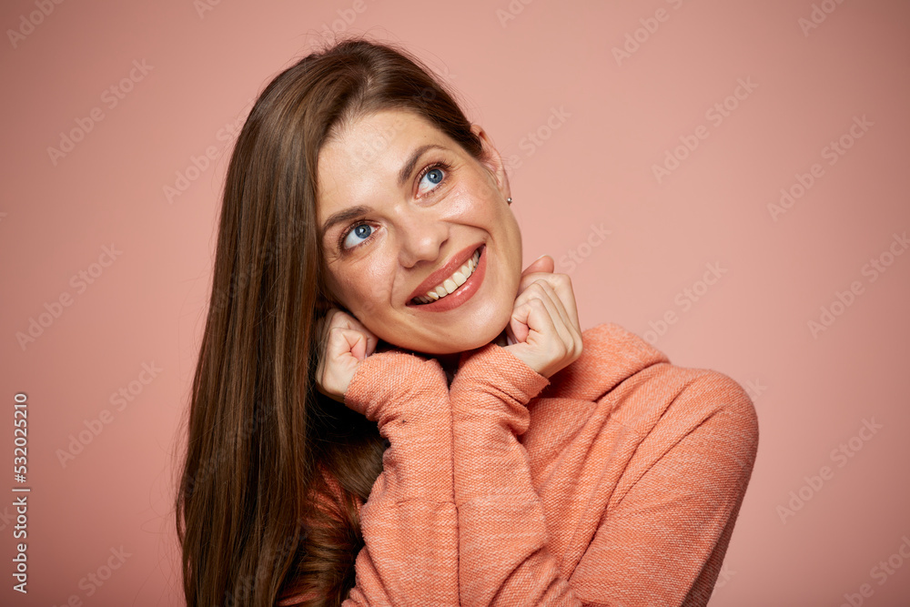 Woman face with natural real skin. Isolated portrait on pink background of smiling girl leaned on hands looking up. Woman face with natural real skin. Isolated portrait on pink background of smiling girl leaned on hands looking up.