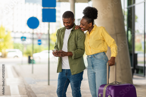 Black Tourists Spouses Using Cellphone Standing With Suitcase Near Airport