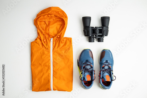 Fotografija Binoculars, tourist backpack, raincoat on a white background