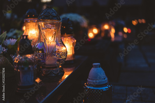 lit candles (lanterns) in the cemetery decorating graves during the Polish All Saints Day on November 1. Evening. Night. Blurred background. All Souls' Day. photo