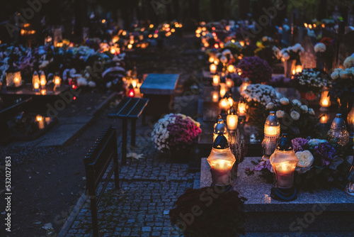 lit candles (lanterns) in the cemetery decorating graves during the Polish All Saints Day on November 1. Evening. Night. Blurred background. All Souls' Day.