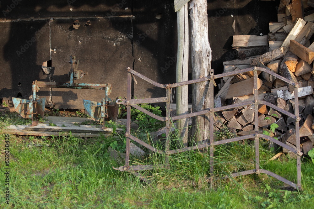 Old plow and harrow for motor tiller on old shed background . Rural farm Old plow and harrow for motor tiller on old shed background . Rural farm