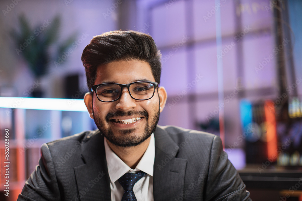 Close up portrait of confident indian businessman trader or economist in formal wear and glasses, posing on camera on night office. Close up portrait of confident indian businessman trader or economist in formal wear and glasses, posing on camera on night office.