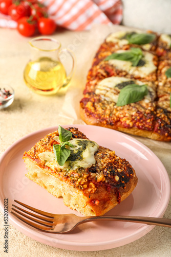 Plate of tasty Italian pie with mozzarella and pesto sauce on light background, closeup