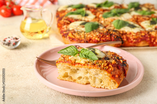 Plate of tasty Italian pie with mozzarella and pesto sauce on table