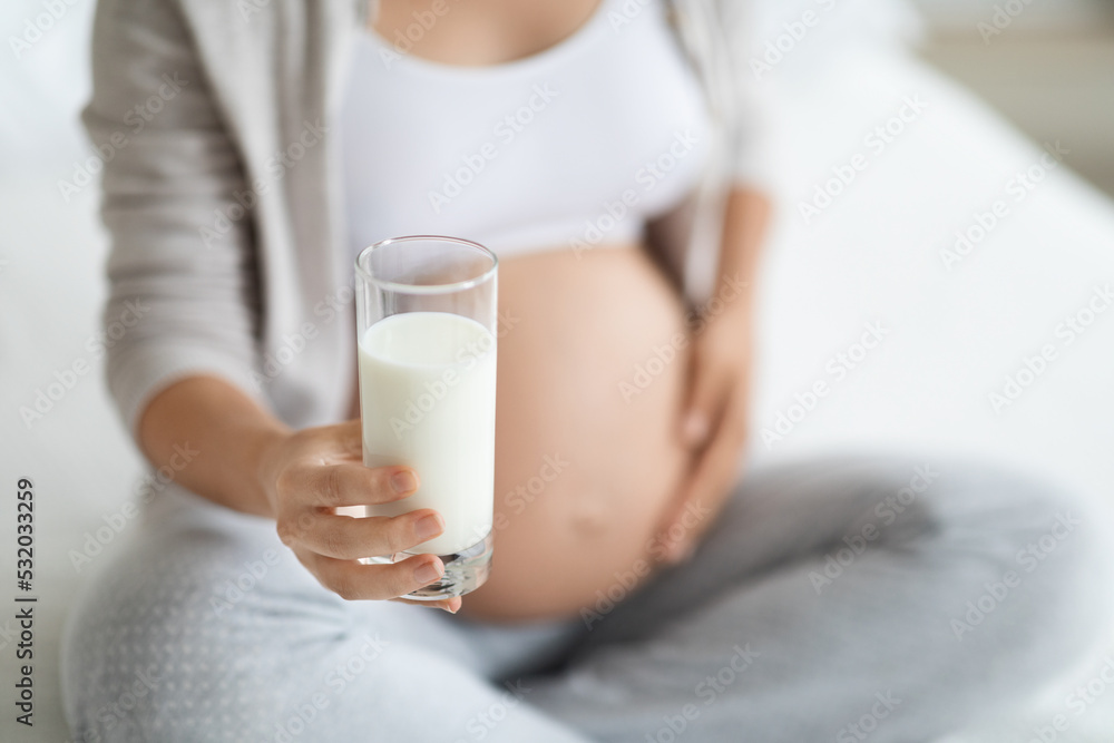Unrecognizable pregnant woman holding glass of milk, cropped Unrecognizable pregnant woman holding glass of milk, cropped