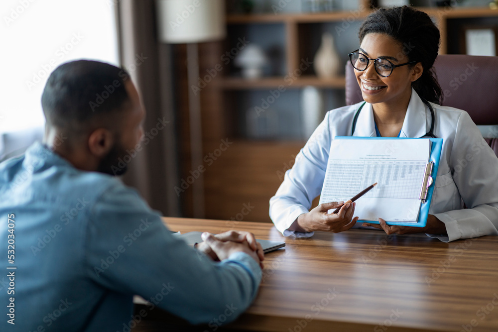 Cheerful african american woman doctor showing patient treatment plan - obrazy, fototapety, plakaty 