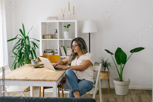 Adult woman working from home using her laptop