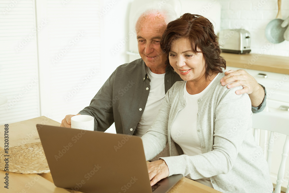 Elderly husband and wife using digital tablet at home, kitchen room Elderly husband and wife using digital tablet at home, kitchen room