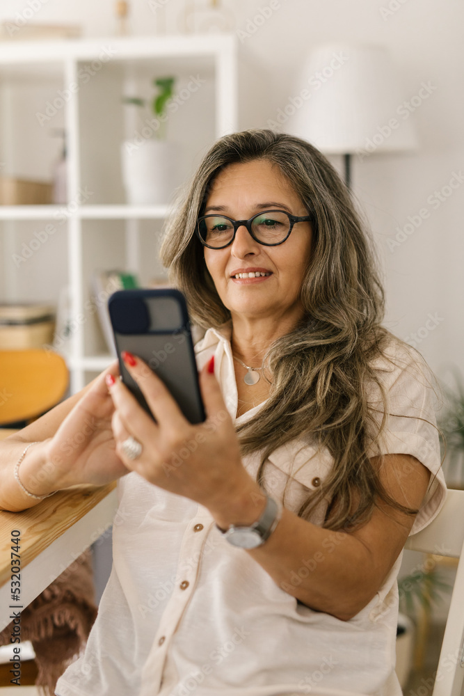 Woman using smartphone and taking pictures at home