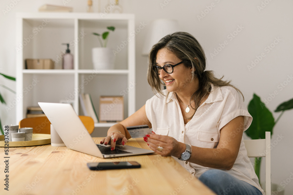 Smiling female shopping online via laptop at home Smiling female shopping online via laptop at home