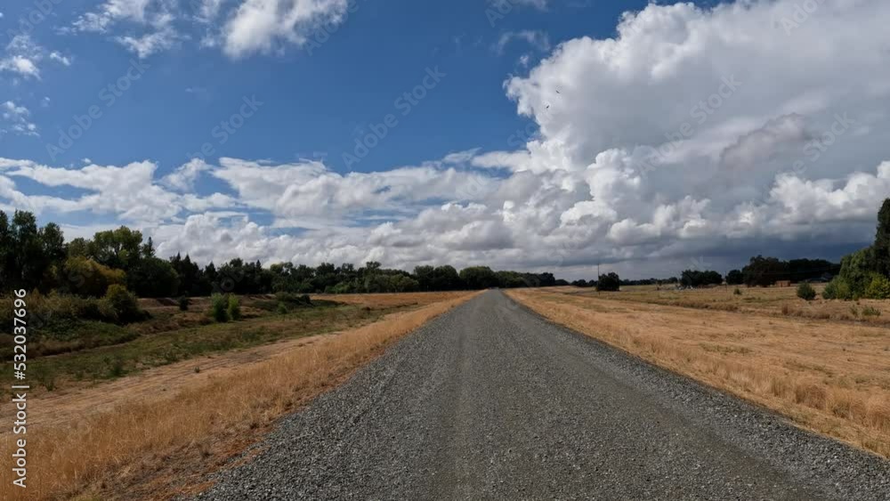 Walking on a levee road near the sacramento river on a cloudy day with vultures in the air Walking on a levee road near the sacramento river on a cloudy day with vultures in the air