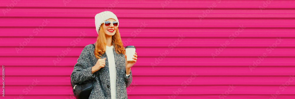 Portrait of beautiful smiling young woman wearing gray coat, white hat on colorful pink background Portrait of beautiful smiling young woman wearing gray coat, white hat on colorful pink background