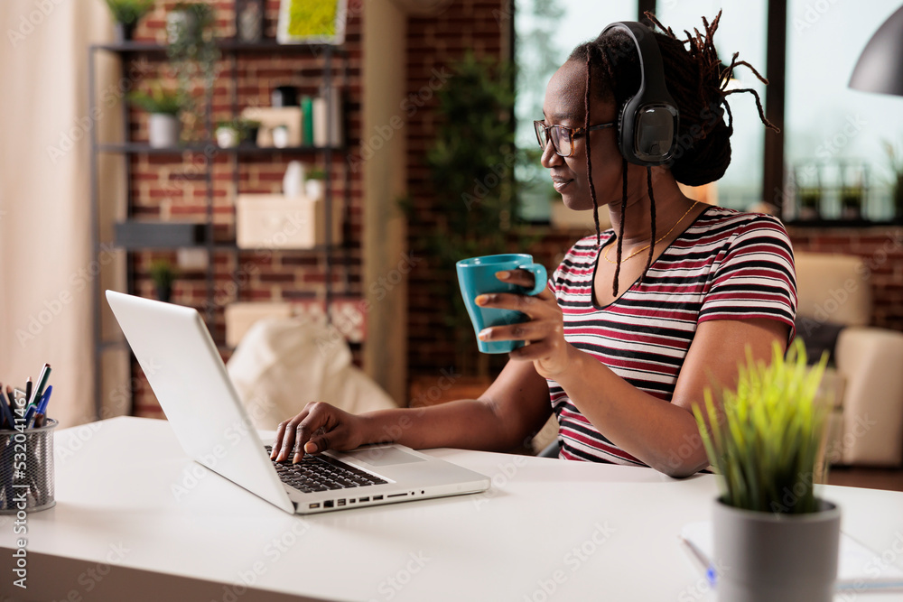 Smiling woman in wireless headphones watching movie online on