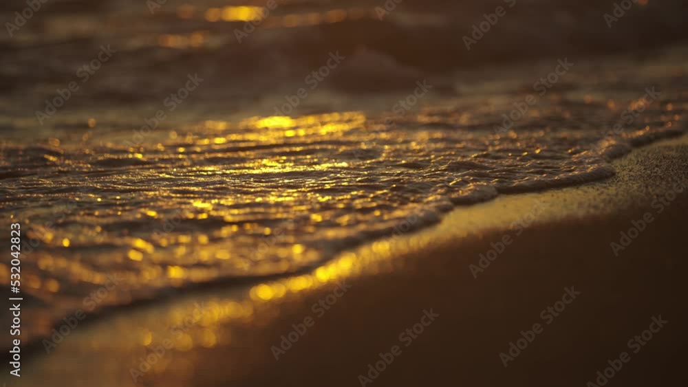 Blue sky over sea with waves against the beach at sunset. Waves floating in slow-motion