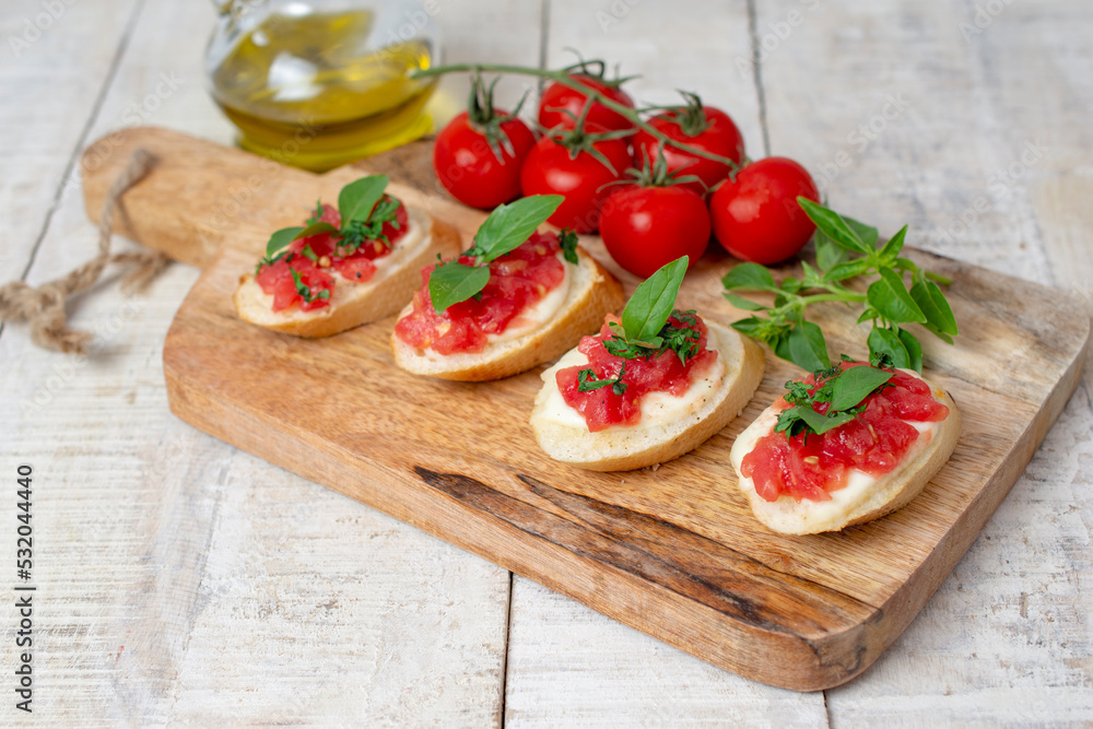 Italian bruschetta with roasted cherry tomatoes, mozzarella cheese and basil on a cutting board. top view Italian bruschetta with roasted cherry tomatoes, mozzarella cheese and basil on a cutting board. top view