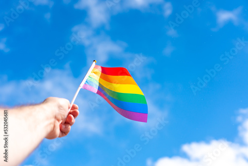 The flag of the LGBT aspiring to the sky as a sign of a sexual minority in the hand