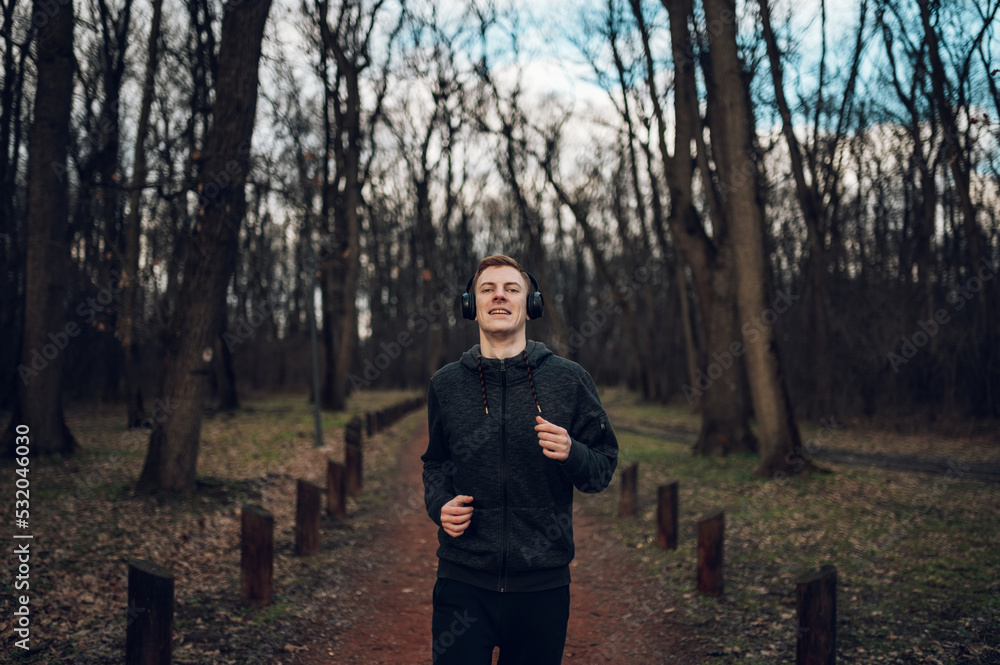 Fototapeta premium Young redhead man running in forest