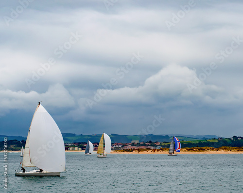 Sailing competition in the Bay of Santander under a cloudy sky