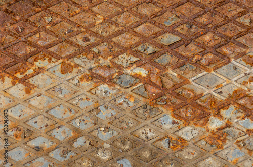 Industrial old rust metal steel surface with rhombus shapes or checkered plates. Rusty metal background with two horizontal shadows