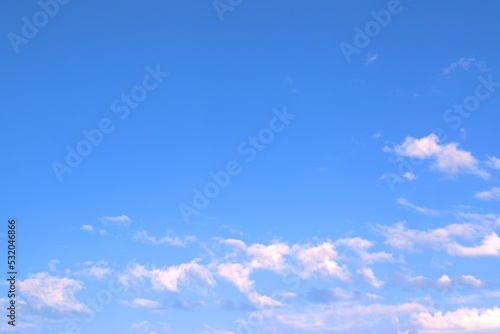 Clear, peaceful blue sky, over which white clouds float slowly like waves Background Banner Screen saver on the monitor.