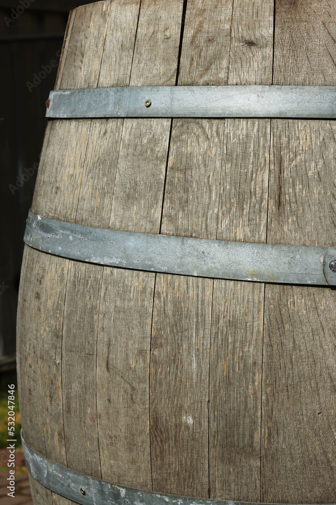 Germany. Heidelberg Castle. Fragment of an old wooden vine barrel with an metall hoop on a dark background. Wooden barrel with metall straps. Wood texture. Side view. Close-up. Macro. Copy space Germany. Heidelberg Castle. Fragment of an old wooden vine barrel with an metall hoop on a dark background. Wooden barrel with metall straps. Wood texture. Side view. Close-up. Macro. Copy space