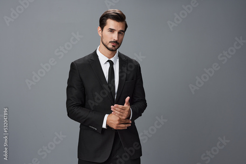 Man confident businessman in a stylish suit with jacket tie and white shirt on a gray background portrait. The concept of young businesses and startups