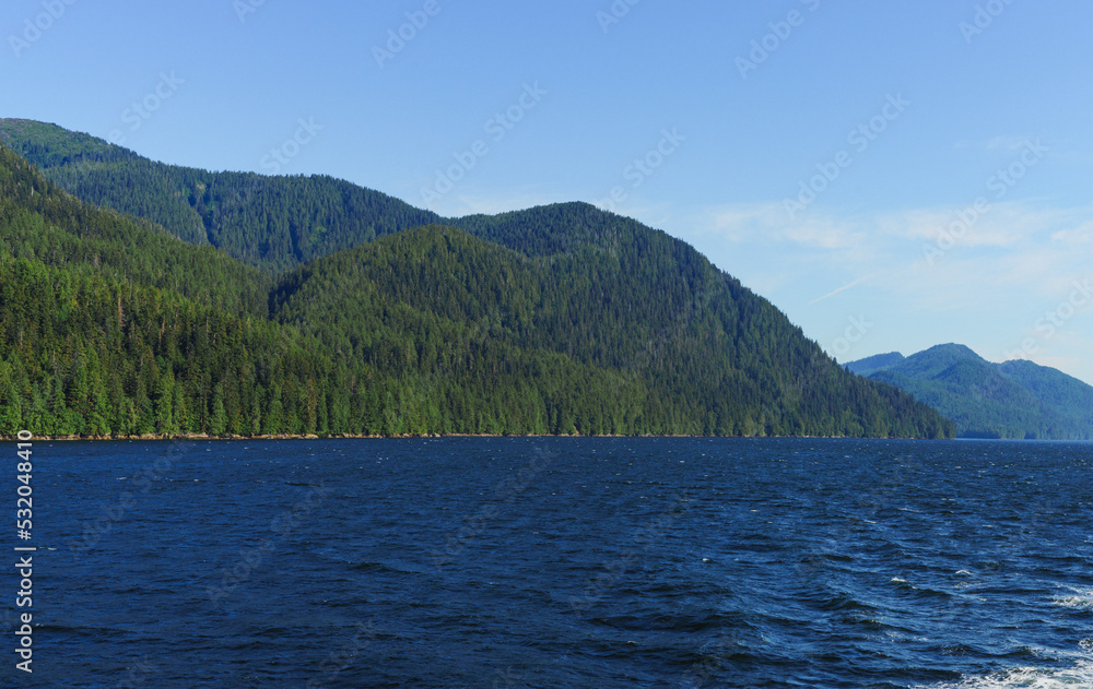 BC seascape in summer with gently rippling waves and mountainous coastline.
