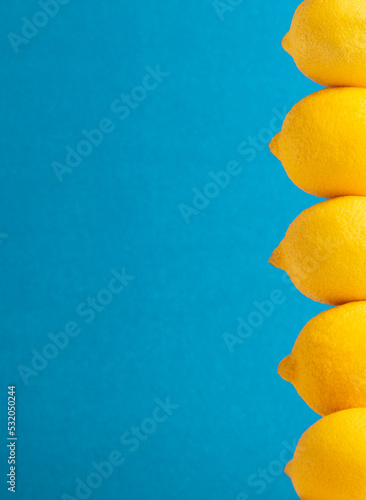 Bright yellow lemons on a blue background, with room for copy