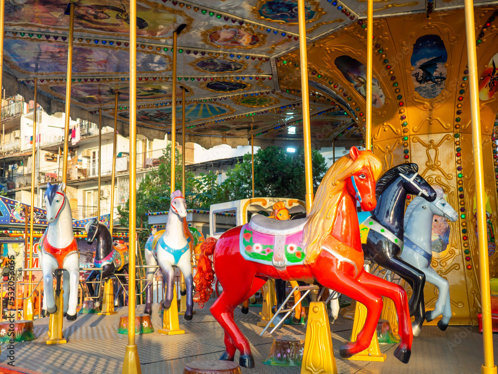 Carousel with horses. Bright attraction for children. Entertainment in the park. Toy horses. Driving in a circle. Children's fun.
