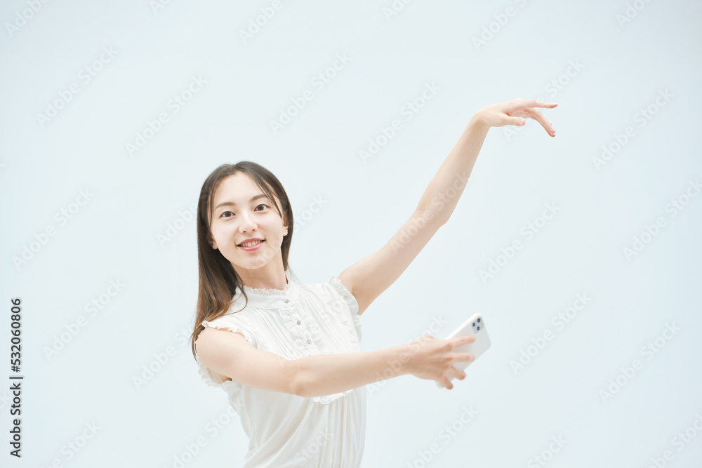 スマートフォンを持ちながら舞う若い女性