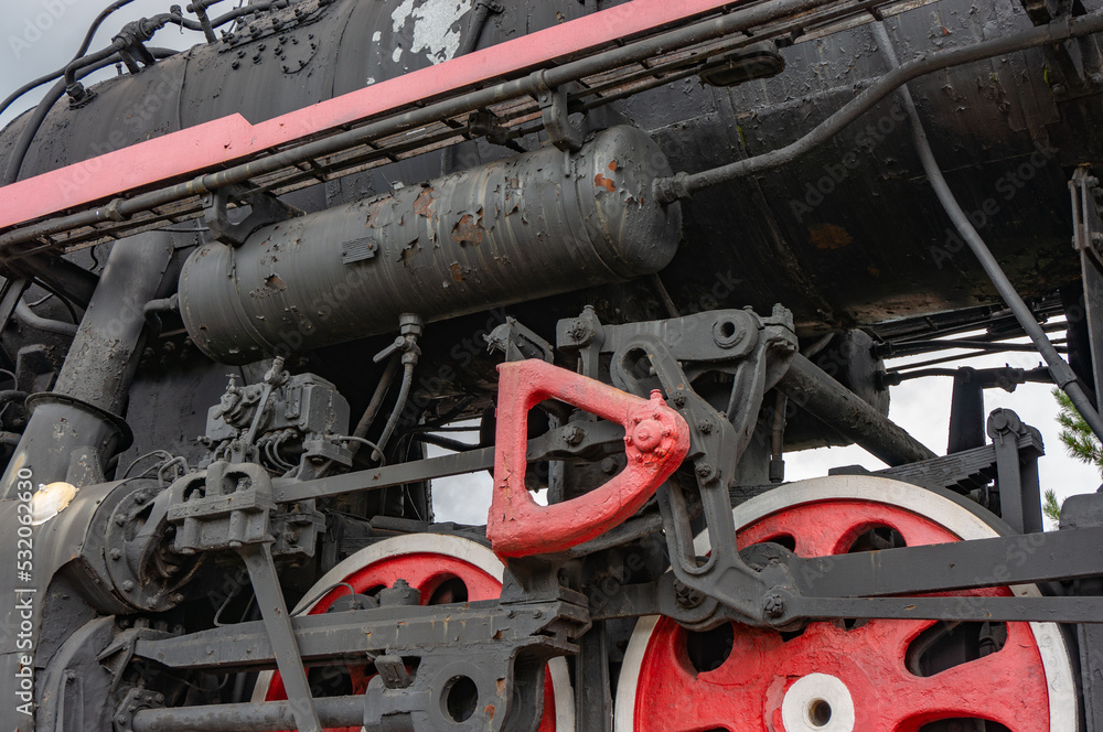 Train drive mechanism and red wheels of an old soviet steam locomotive.